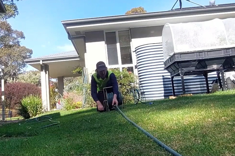 
With the day`s work completed, the batemansbay downpipe cleaner is rolling up his hose.